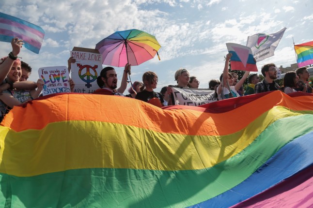 SAINT PETERSBURG, RUSSIA - 2017/08/12: Peserta memegang bendera pelangi yang umumnya dikenal sebagai bendera kebanggaan LGBT selama demonstrasi Gay Pride di Champ de Mars. Beberapa lusin orang datang ke Champ de Mars di Saint Petersburg untuk berpartisipasi dalam LGBT Pride of Saint Petersburg ke-8. (Foto oleh Igor Russak/SOPA Images/LightRocket melalui Getty Images)