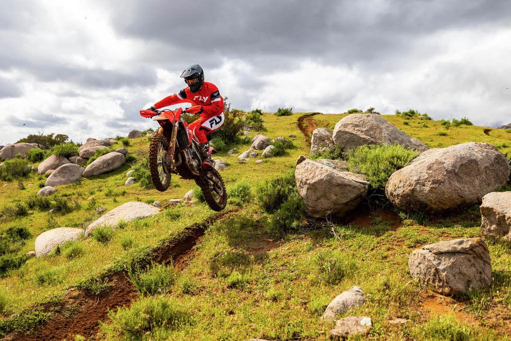 Sepeda motorcross Jepang berwarna merah di tengah penerbangan