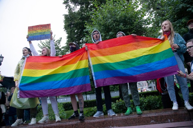 FILE - Aktivis LGBT mengibarkan bendera mereka saat unjuk rasa untuk membatalkan hasil pemungutan suara mengenai amandemen konstitusi di Moskow, Rusia, Rabu, 15 Juli 2020. Kementerian Kehakiman Rusia menyatakan telah mengajukan gugatan ke Mahkamah Agung negara tersebut untuk melarang LGBTQ "gerakan publik internasional" sebagai seorang ekstremis. (Foto AP, file)