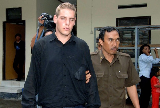 DENPASAR, INDONESIA: Matthew Norman dari Australia (kiri), dijatuhi hukuman mati karena mencoba menyelundupkan heroin ke luar Indonesia, diantar ke pengadilan untuk diadili di Denpasar di pulau Bali, 9 Mei 2007. Tiga warga Australia, Si Yi Chen , Tan Duc Thanh Nguyen dan Matthew Norman yang merupakan bagian dari apa yang disebut "Bali Baru" kelompok tersebut dan mereka yang dijatuhi hukuman mati, mengajukan permohonan peninjauan kembali atas kasus mereka, dengan alasan bahwa Mahkamah Agung Indonesia telah melakukan kesalahan dalam memerintahkan eksekusi mereka. Ketiga pria tersebut ditangkap di sebuah kamar hotel di pulau resor Indonesia, Bali, dengan membawa sejumlah kecil heroin pada tahun 2005, tak lama setelah orang lain ditangkap di bandara. AFP PHOTO/Sonny TUMBELAKA (Kredit foto harus dibaca SONNY TUMBELAKA/AFP via Getty Images)