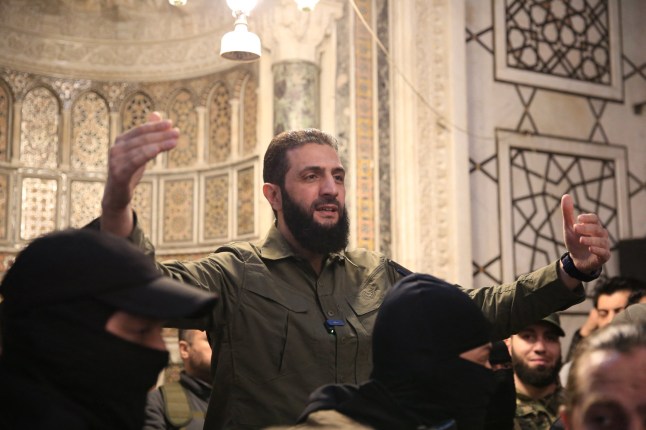 TOPSHOT - Pemimpin kelompok Islam Suriah Hayat Tahrir al-Sham (HTS) yang memimpin serangan pemberontak yang merebut Damaskus dari kendali pemerintah, Abu Mohammed al-Jolani, berpidato di depan kerumunan orang di luar Masjid Umayyah yang ikonik di ibu kota, pada 8 Desember , 2024. Jolani yang kini menggunakan nama aslinya Ahmed al-Sharaa berpidato diiringi massa yang meneriakkan yel-yel "Allahu Akbar (Allah Maha Besar)," menunjukkan video yang dibagikan oleh pemberontak di saluran Telegram mereka. (Foto oleh Aref TAMMAWI/AFP) (Foto oleh AREF TAMMAWI/AFP via Getty Images) ***BESTPIX***