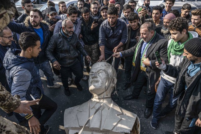 DAMASKUS, SURIAH - 9 DESEMBER: Warga Suriah membongkar patung Hafez al-Assad, ayah Bashar al-Assad, di Damaskus, Suriah pada 9 Desember 2024. Dengan runtuhnya rezim Ba'ath di Suriah pada hari Minggu dan runtuhnya rezim Ba'ath di Suriah pada hari Minggu. akhir dari keluarga Assad Sekitar waktu ini, warga Suriah terlihat merobohkan patung Hafez al-Assad, ayah dari Presiden terguling Bashar al-Assad, di berbagai kota di seluruh negeri. negara. negara. (Foto oleh Murat Sengul/Anadolu melalui Getty Images)
