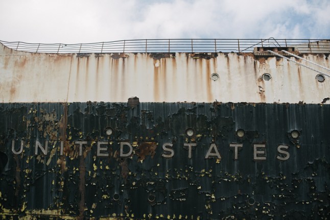 Catnya terkelupas di sekitar kata-katanya "AMERIKA SERIKAT" dicetak pada bagian luar kapal laut pensiunan SS Amerika Serikat di Pier 82 di Philadelphia, Pennsylvania, Amerika Serikat, pada hari Jumat, 28 Februari 2020. RXR Realty telah mencapai kesepakatan dengan pemilik nirlaba SS Amerika Serikat dan merencanakan sejumlah uang dari $500 konversi satu juta dolar? kapal yang akan mencakup kamar hotel, restoran, dan museum yang merayakan sejarah kapal. ? Fotografer: Hannah Yoon/Bloomberg melalui Getty Images