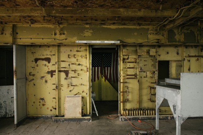 Bendera Amerika dikibarkan di depan kusen pintu di dalam ruang observasi kapal laut pensiunan SS Amerika Serikat di Pier 82 di Philadelphia, Pennsylvania, AS, Jumat, 28 Februari 2020. RXR Realty menutup kesepakatan dengan Pemilik SS non -mendapatkan keuntungan di Amerika Serikat, ia merencanakan konversi kapal senilai $500 juta yang akan mencakup kamar hotel, restoran, dan museum yang merayakan sejarah kapal tersebut. Fotografer: Hannah Yoon/Bloomberg melalui Getty Images