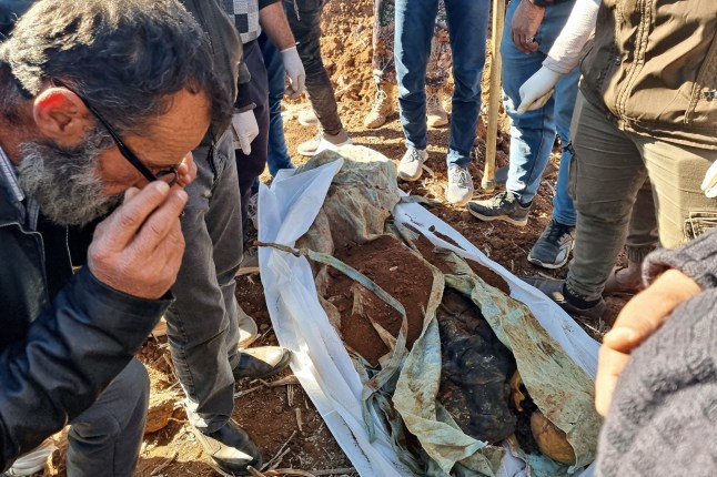 Petugas kesehatan memeriksa sisa-sisa manusia dari kuburan massal yang baru-baru ini ditemukan di sebuah ladang pertanian di Izra, provinsi Daraa, Suriah selatan, 16 Desember 2024. Pemberontak yang dipimpin Islam merebut Damaskus dalam serangan kilat pada 8 Desember, menggulingkan Presiden Bashar al-Assad dan mengakhiri lima dekade pemerintahan Baath di Suriah. Menurut Observatorium Suriah untuk Hak Asasi Manusia, lebih dari 100.000 orang telah tewas di penjara dan pusat penahanan Suriah sejak tahun 2011. (Foto oleh Sam HARIRI / AFP) (Foto oleh SAM HARIRI/AFP via Getty Images)