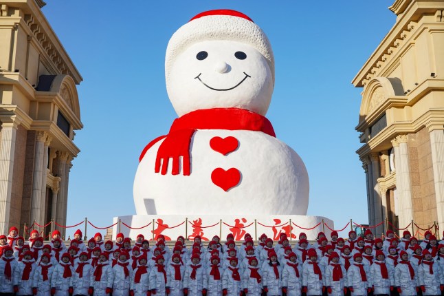 HARBIN, CHINA - 17 DESEMBER: Sebuah pertunjukan dipentaskan pada upacara peluncuran manusia salju raksasa yang mengenakan syal merah di Harbin Music Park pada 17 Desember 2024 di Harbin, provinsi Heilongjiang, Tiongkok. Seorang teman lama dari Harbin, manusia salju raksasa mengadakan pertemuan tahunannya dengan penduduk setempat untuk pertama kalinya muncul pada musim dingin ini di sebuah taman di kota Harbin, provinsi Heilongjiang. (Foto oleh Zhao Yuhang/China News Service/VCG melalui Getty Images)