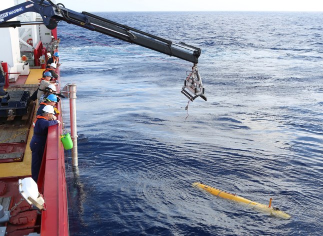 DI LAUT - 14 APRIL: Dalam gambar yang disediakan oleh Departemen Pertahanan Persemakmuran Australia, kendaraan bawah air otonom (AUV) Bluefin-21 Phoenix direntangkan di sisi kapal pertahanan Australia Ocean Shield mencari Malaysia Airlines Penerbangan MH yang hilang. 370 pada tanggal 14 April 2014. Dua puluh enam negara telah berpartisipasi dalam pencarian Malaysia Airlines Penerbangan MH370 sejak hilang lebih dari sebulan yang lalu. (Foto oleh LEUT Kelli Lunt/Departemen Pertahanan Australia via Getty Images)