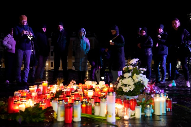 Orang-orang menyalakan lilin di depan Katedral Magdeburg setelah upacara peringatan bagi para korban serangan pasar Natal pada hari Jumat, di mana sebuah mobil melaju ke arah kerumunan, di Magdeburg, Jerman, Sabtu, 21 Desember 2024. ( AP Photo/Ebrahim Noroozi)