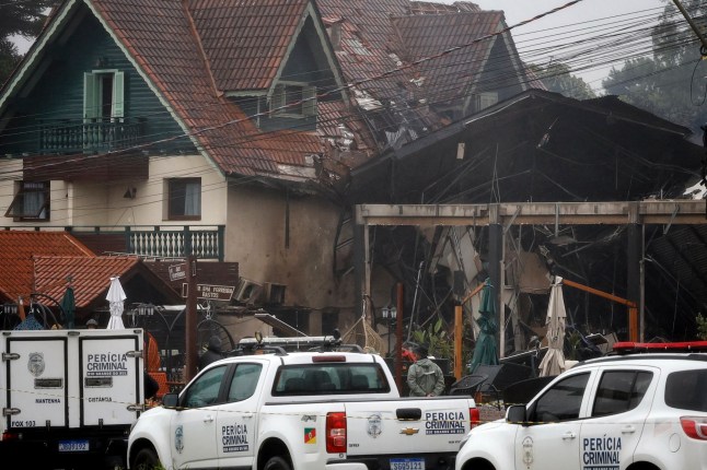 Polisi menutup rumah-rumah yang ditabrak pesawat di Gramado, negara bagian Rio Grande do Sul, Brasil, Minggu, 22 Desember 2024. (AP Photo/Mateus Bruxel, Ag??ncia RBS)