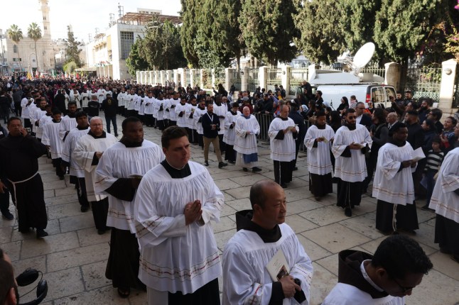epa11791994 Para pendeta menunggu Patriark Latin Pierbattista Pizzaballa (tidak dalam gambar) memasuki Gereja Kelahiran selama prosesi tradisional Kristen menuju Gereja Kelahiran, di kota Betlehem, Tepi Barat, 24 Desember 2024. Gereja Kelahiran adalah salah satu gereja tertua yang beroperasi di dunia. Strukturnya dibangun di atas gua yang secara tradisi disebut sebagai tempat kelahiran Kristus dan dianggap suci oleh penganut agama Kristen. EPA/ALAA BADARNAH