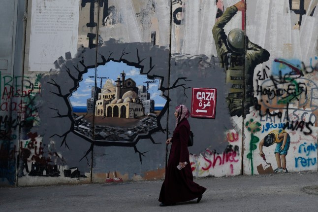 Mural menutupi tembok pemisah Israel di kota Betlehem Tepi Barat pada Malam Natal, Selasa, 24 Desember 2024. (AP Photo/Matias Delacroix)