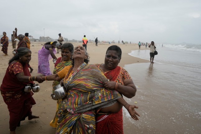 Seorang wanita India menangis saat dia dan orang lain memberikan penghormatan kepada para korban tsunami 2004, menandai peringatan 20 tahun tragedi tersebut, di Pantai Marina di Chennai, India, Kamis, 26 Desember 2024.