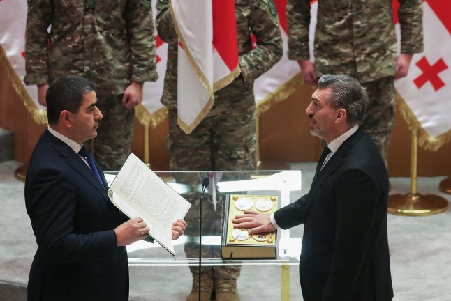 Mikheil Kavelashvili (kanan), dipilih oleh anggota parlemen sebagai presiden baru Georgia, mengambil sumpah jabatan pada upacara pelantikannya di parlemen di Tbilisi, 29 Desember 2024. Mantan pesepakbola sayap kanan itu mengambil sumpah dalam 'upacara parlemen beberapa saat setelah keluar Presiden Salomé Zurabishvili menyatakan bahwa dia adalah "satu-satunya presiden yang sah" dan berjanji untuk melawan partai Impian Georgia yang menguasai Parlemen. (Foto oleh Irakli Gedenidze / AFP) (Foto oleh IRAKLI GEDENIDZE/AFP via Getty Images)