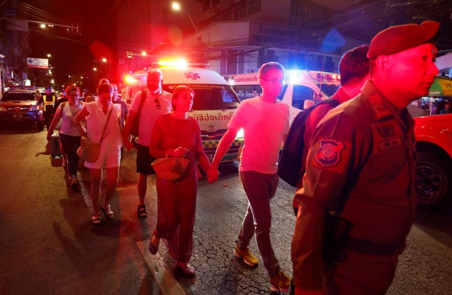 epa11797904 Seorang petugas polisi wisata mengawal wisatawan yang dievakuasi pasca kebakaran di Hotel Ember di Bangkok, Thailand, 29 Desember 2024. Menurut polisi di lokasi kejadian, sejumlah korban dilaporkan ketika terjadi kebakaran di hotel dekat lokasi tersebut. lokasi hotel di Jalan Khao San.